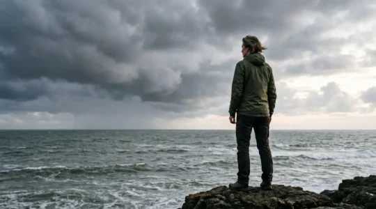 Silhouette sereine face a une mer agitee, symbole de la resilience mentale construite en amont d'une crise