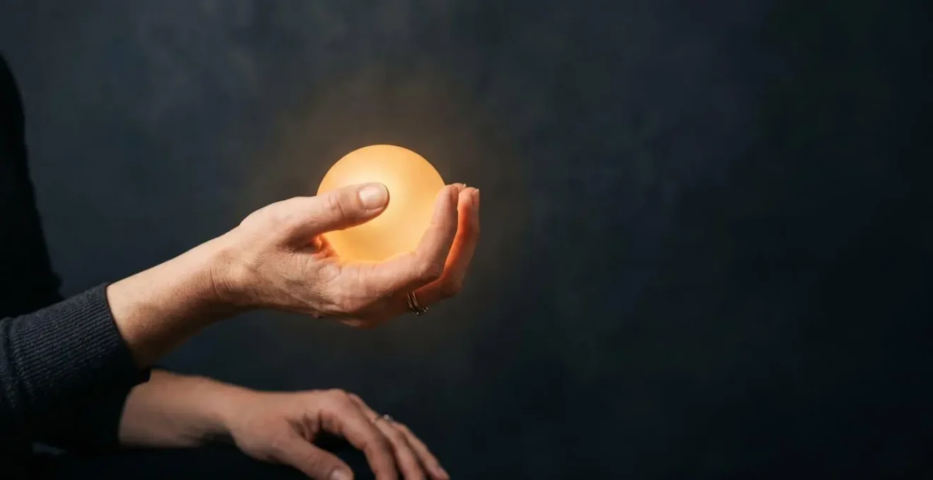 Une main façonnant délicatement une forme lumineuse et dorée, symbolisant la transformation d'un talent naturel en valeur concrète