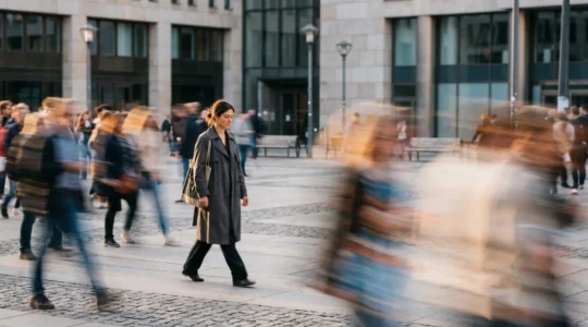 Une personne marche lentement et sereinement pendant qu'une foule floue se précipite autour d'elle, symbolisant le choix de ralentir
